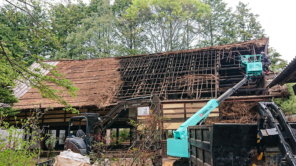 茅葺屋根の解体は、予想以上に骨の折れる作業でした。急勾配の屋根に、伝統的な竹編み構造。さらに、茅の中には長年の煤（すす）が堆積していて、作業中はみるみる体が真っ黒に。